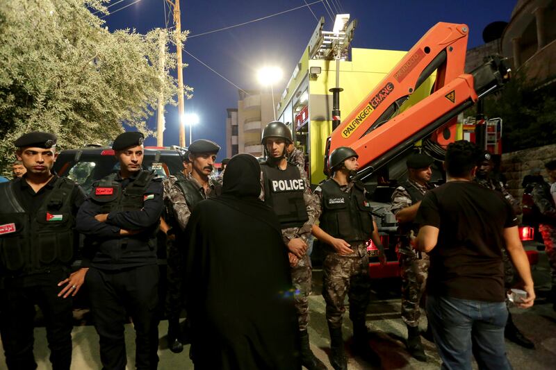 Jordanian police surround the area as Civil Defence teams conduct a search operation for residents of the building. AP