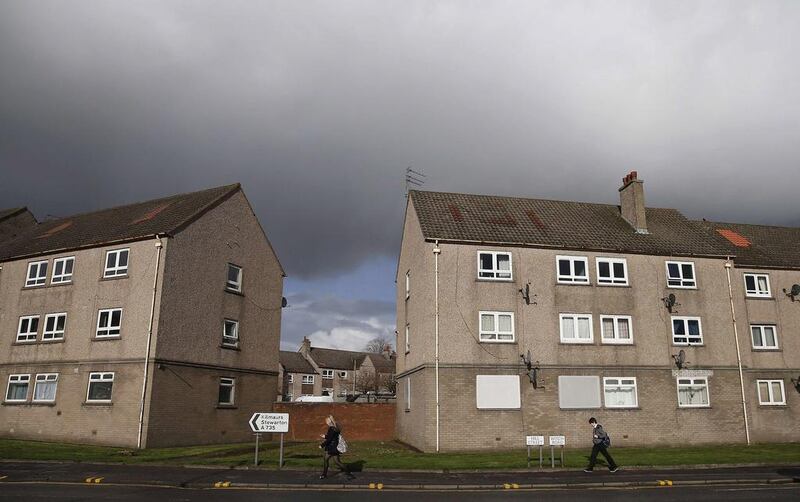 Pedestrians walk past a row of flats across from the former site of the Johnnie Walker distillery in Kilmarnock, Scotland. Suzanne Plunkett / Reuters