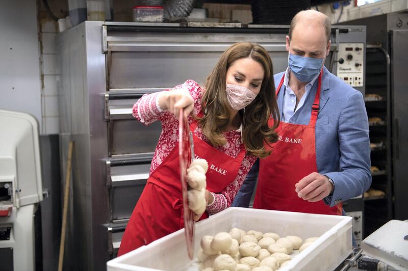 LONDON, ENGLAND - SEPTEMBER 15: Prince William, Duke of Cambridge and Catherine, Duchess of Cambridge pour a tray of dough into a container as they help make beigels during a visit to Beigel Bake Brick Lane Bakery on September 15, 2020 in London, England. The 24-hour bakery was forced to reduce their opening hours during the pandemic and The Duke and Duchess heard how this affected employees, as well as the ways in which the shop has helped the local community through food donation and delivery. (Photo by Justin Tallis - WPA Pool/Getty Images)