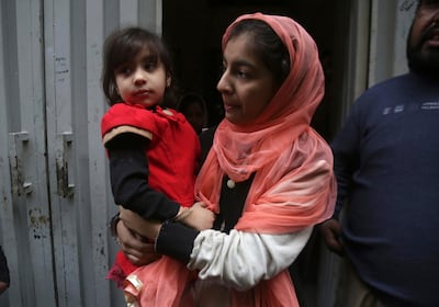 Hadiya Khalil, left, who survived a shoot-out by counter-terrorism officers, is carried by an unidentified relative at her home in Lahore, Pakistan, Sunday, Jan. 20, 2019. Authorities in Pakistan have arrested counter-terrorism police officers after they killed a middle-aged couple, their 13-year-old daughter and another man in what the police initially claimed was a shootout with insurgents. (AP Photo/K.M. Chaudary)
