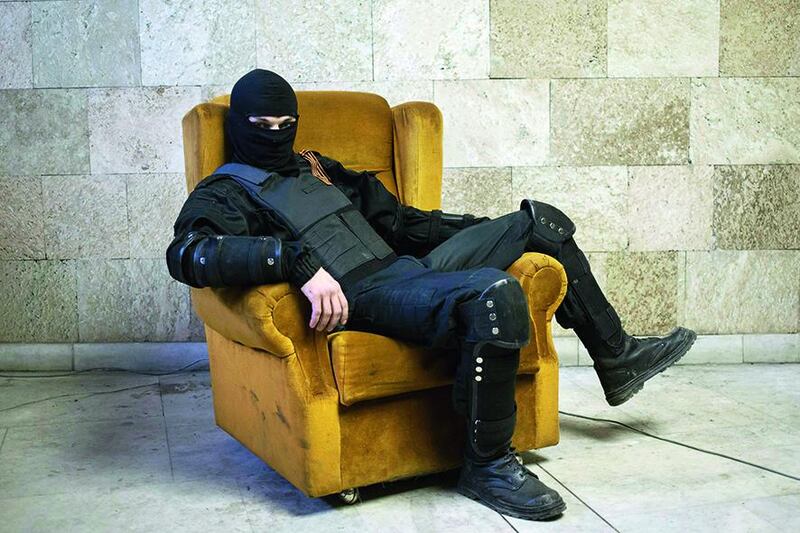 A masked pro-Russian protester sits on a chair as he poses for a picture inside a regional government building in Donetsk, eastern Ukraine in this April 25 file photo.  Marko Djurica / Reuters
