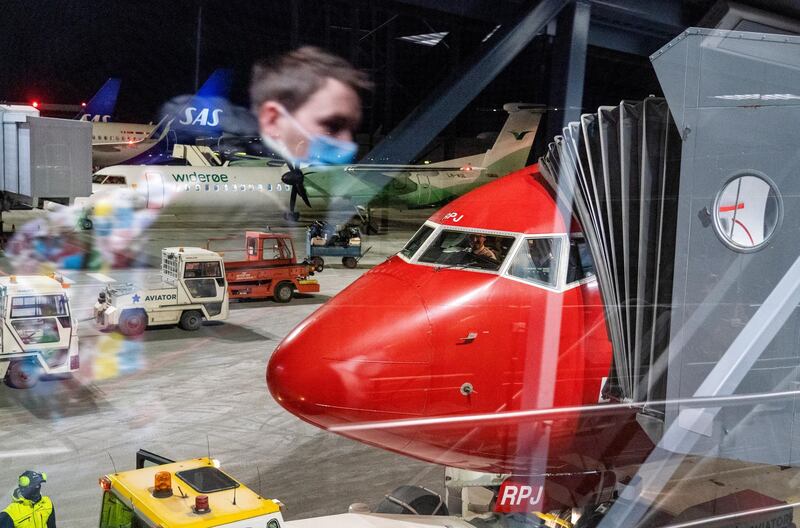 People wait to board a plane from Vaernes airport in Trondheim, Norway. NTB via AP