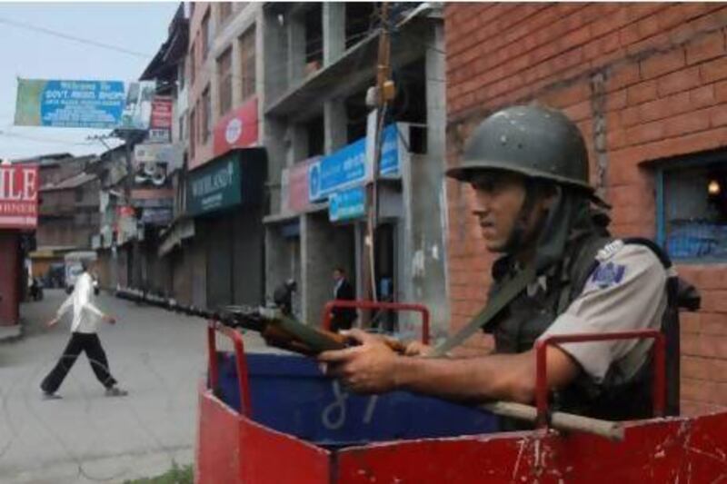 An Indian paramilitary soldier stands guard outside his post during a strike in Srinagar.