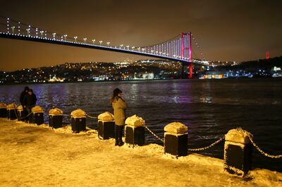 People stand in the snow over the Bosporus Strait at Istanbul. AP Photo / Emrah Gurel