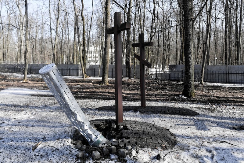 A Russian cluster bomb is seen next to a cross at a war cemetery in Kharkiv, Ukraine. EPA
