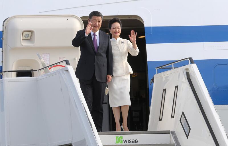 China's President Xi Jinping (L) and his wife Peng Liyuan wave after arriving at Tegel airport in Berlin on July 4, 2017 where he is set to have dinner with German Chancellor Angela Merkel.  / AFP PHOTO / dpa / Wolfgang Kumm / Germany OUT