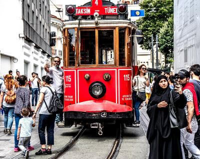 epa06839122 People pose in front of nostalgic tram on Istiklal Street in Istanbul, Turkey, 25 June 2018. Some 56.3 million registered citizens voted in snap presidential and parliamentary elections to elect 600 lawmakers and the country's president, the first election since the Turkish people in a referendum in April 2017 voted to change the country's system from a parliamentary to a presidential republic.  EPA/SRDJAN SUKI