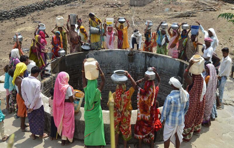 Indian women from the aboriginal Kol community collect drinking water at a well in Nawargawa village in Madhya Pradesh state. AFP