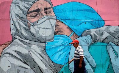 TOPSHOT - A man walks past a coronavirus-related mural, in Acapulco, Guerrero state, Mexico, on May 1, 2020. / AFP / FRANCISCO ROBLES
