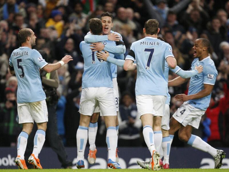 Manchester City's Stevan Jovetic, centre, celebrates scoring the opening goal in his team's FA Cup fifth-round match against Chelsea at the Etihad Stadium on Saturday. Jon Super / AP Photo