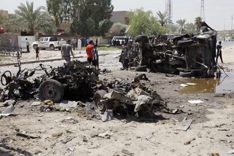 Civilians inspect the aftermath of a car bombing in Baghdad.