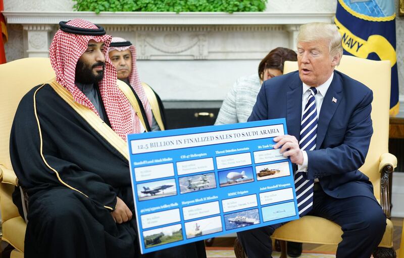 TOPSHOT - US President Donald Trump (R) holds a defence sales chart with Saudi Arabia's Crown Prince Mohammed bin Salman in the Oval Office of the White House on March 20, 2018 in Washington, DC. / AFP PHOTO / MANDEL NGAN