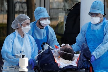 Medical staff move a patient from a special high-speed train to an ambulance during a transfer operation of people infected with Covid-19. REUTERS