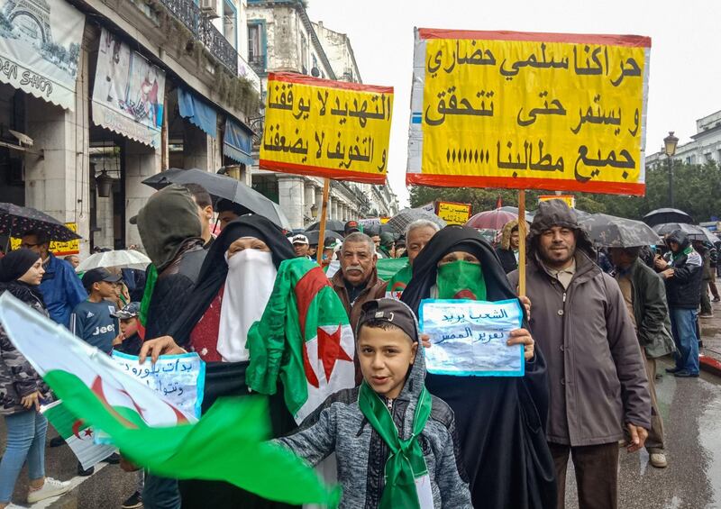 Algerians march with signs reading in Arabic "our movement is peaceful and civilised and will continue until all our demands our met" and "threats do not impede us nor does intimidation weaken us", as they take part in an anti-government demonstration in the northeastern city of Annaba.  AFP