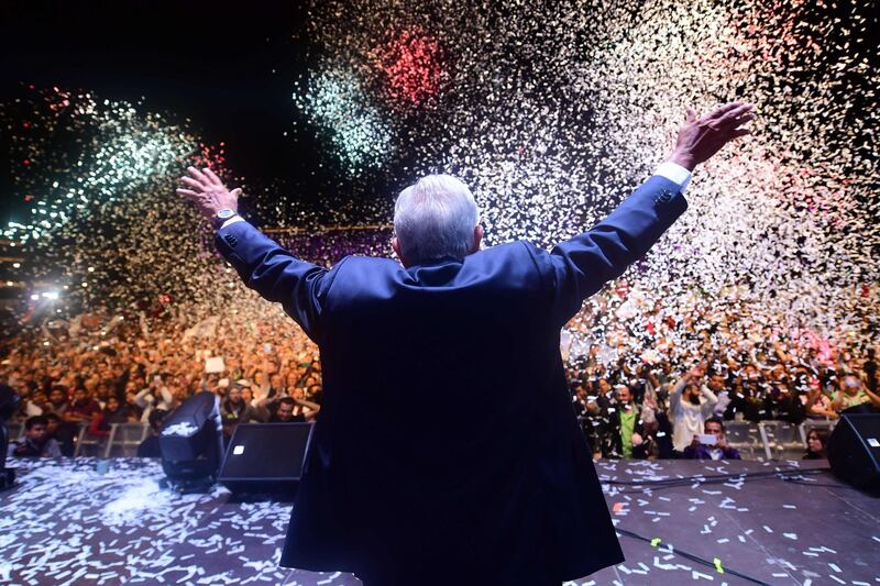 Newly elected Mexico's President Andres Manuel Lopez Obrador (C), running for "Juntos haremos historia" party, cheers his supporters at the Zocalo Square after winning general elections, in Mexico City, on July 1, 2018.  Pedro Pardo / AFP