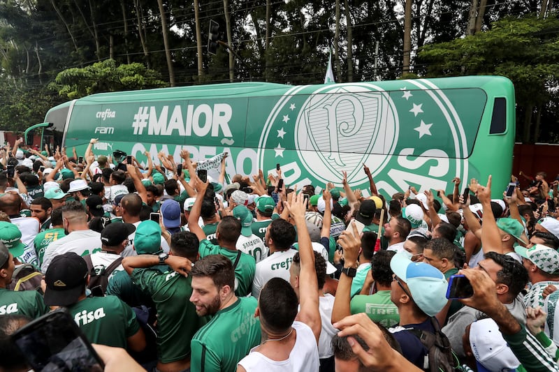 Fans of Brazilian football club Palmeiras cheer as the team bus exits the training centre in Sao Paulo, Brazil. The team are en route to Abu Dhabi for the Fifa Club World Cup to be held from February 3-12 February in the UAE. AFP