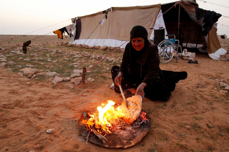 Zahra Buheir, 72, a truffle hunter, makes bread in the desert in Samawa, Iraq. Reuters