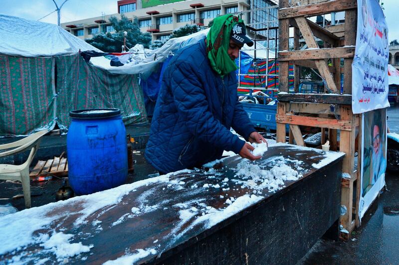 A man touches snow at a sit-in in Tahirir Square. AP Photo