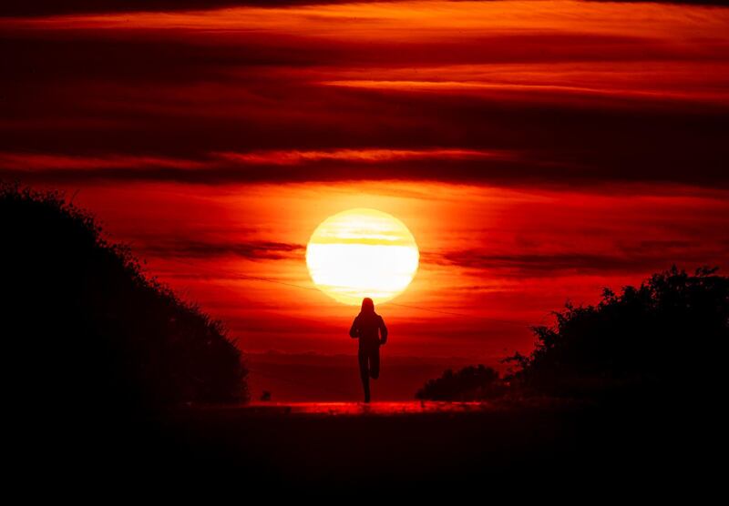 A woman runs as the sun rises in Frankfurt, Germany. AP