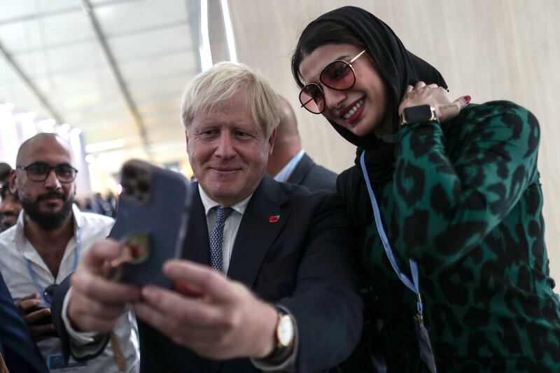 Former British prime minister Boris Johnson poses for a selfie at the event in Sharm El Sheikh. EPA
