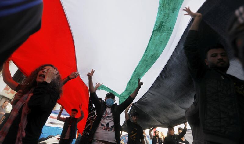 Demonstrators carry huge Iraqi flag during an ongoing anti-government protests. Reuters