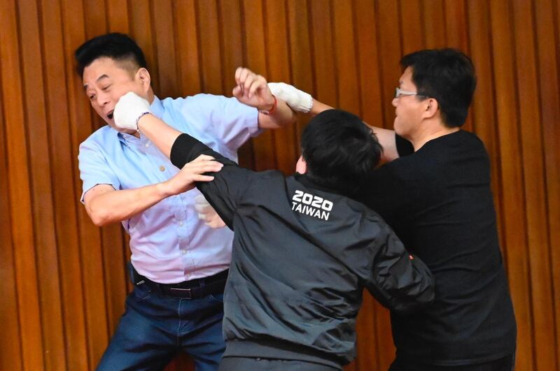 Taiwan’s main opposition Kuomintang legislator Lu Ming-che, left, fights with ruling Democratic Progressive Party (DPP) lawmaker Wu Ping-jui, centre, as scuffles broke out during voting at the parliament in Taipei. AFP