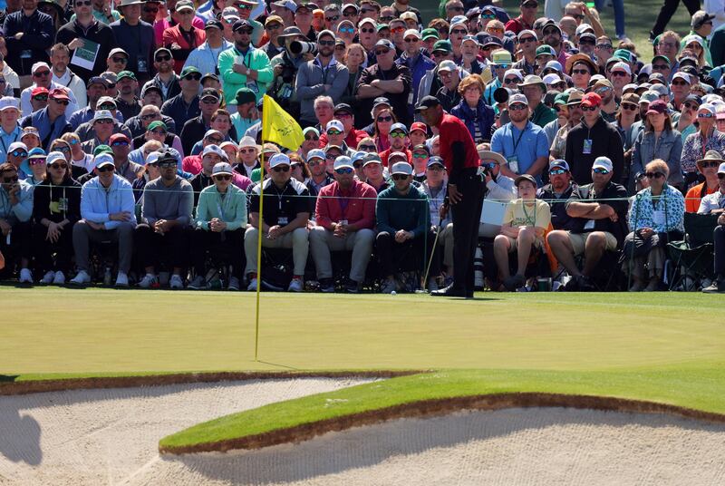 Woods lines up his putt on the 2nd green. Reuters