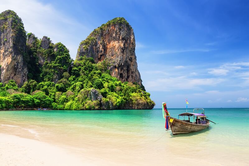 8. Thai traditional wooden longtail boat and beautiful sand at Railay Beach in Krabi province, Thailand.