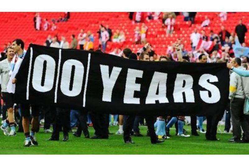 United supporters display a banner in February showing how many years it has been since City won a trophy. Mike Hewitt / Getty Images