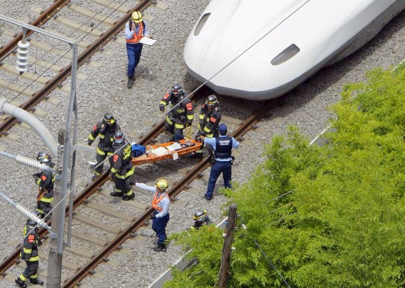 A passenger on the stretcher is carried by rescue workers from a Shinkansen bullet train after it made an emergency stop in Odawara, south of Tokyo, in this aerial view photo taken by Kyodo June 30, 2015. A passenger set himself on fire inside the train, killing himself and another passenger. Kyodo/Reuters