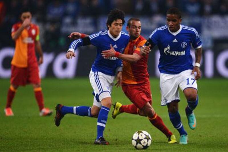 Wesley Sneijder, of Galatasaray, centre, is challenged by Schalke pair Atsuto Uchida and Jefferson Farfan during their Champions League match.