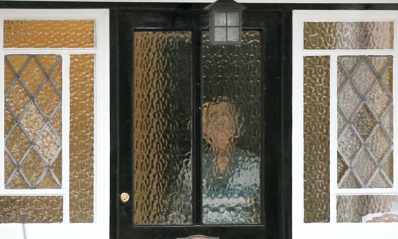 A person stands behind textured glass at an address which has been linked by local media to former British intelligence officer Christopher Steele, who has been named as the author of an intelligence dossier on President-elect Donald Trump, in Wokingham, Britain, January 12, 2016. REUTERS/Peter Nicholls - RTX2YLZ0