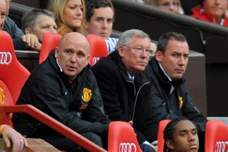 Sir Alex Ferguson, centre, the Manchester United manager, looks on as his team lose 6-1 at home to their city rivals.