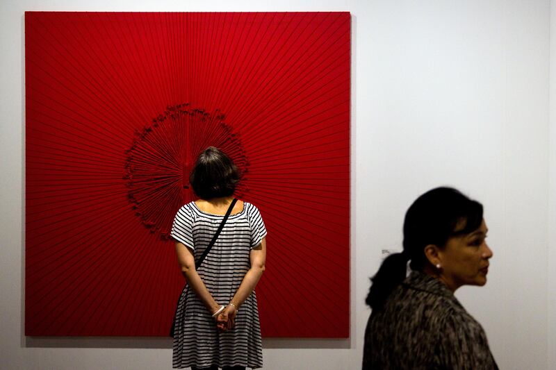 A visitor, left, looks at the artwork "Mandala XI" by Alexandra da Cuhna on display during Art Basel Miami Beach in Miami, Florida, U.S., on Friday, Dec. 2, 2016. Politics is prevalent at Art Basel this week, where artists and galleries are using the biggest contemporary art fair in the U.S. to express frustration and other feelings in the wake of the presidential election. Photographer: Scott McIntyre/Bloomberg