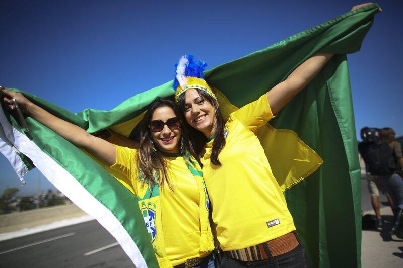 Brazil fans drape themselves in the national flag outside the Arena Corinthians prior to the start of the 2014 World Cup opening match on Thursday. Diego Azubel / EPA