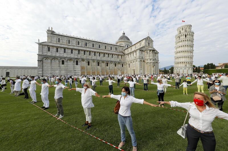 People gather for a flash mob on the Miracle's square to celebrate the reopening of the Leaning Tower, in Pisa, Italy.  EPA