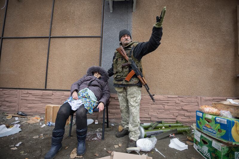 A Ukrainian serviceman helps an elderly woman in Irpin, 20 kilometres north-west of the capital Kyiv.  AP Photo