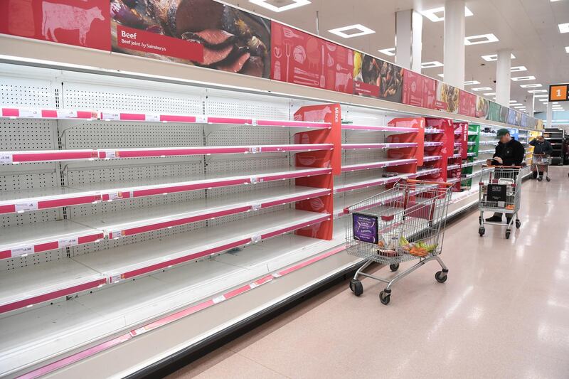 People look on empty shelves in a supermarket in London, Britain. EPA
