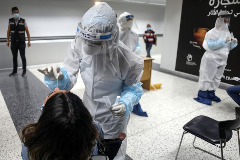 Medical workers wearing personal protective equipment collect Covid-19 swab samples as they test travellers inside the arrivals hall at Rafik Hariri International Airport in Beirut. Bloomberg