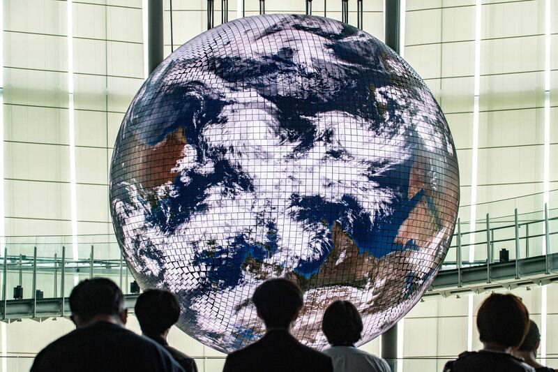 Reporters observe the Geo-Cosmos, the world’s first spherical display made using organic electroluminescent panels showing a high-resolution model of the Earth, during a media preview in Tokyo. AFP
