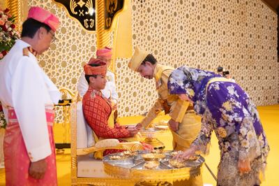 Brunei's Sultan Hassanal Bolkiah and Queen Raja Isteri Pengiran Anak Hajah Saleha with Prince Abdul Mateen during the royal powdering ceremony on January 10. EPA 