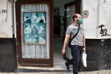 An Algerian man leaves a barber shop after getting a haircut in the capital Algiers after authorities eased some restrictions put in place in a bid to fight the spread of the novel coronavirus. AFP