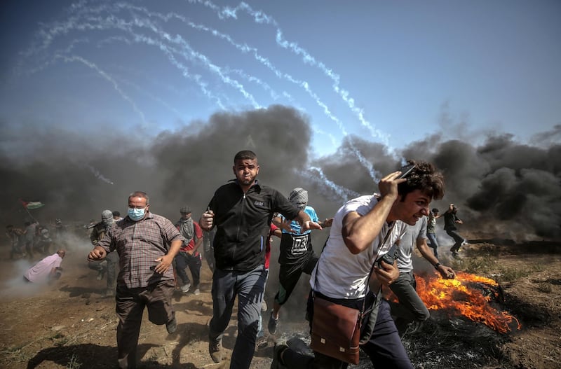 epa06795301 Palestinians protesters run for cover from Israeli tear-gas during the clashes after Friday protest near the border east Gaza City on, 08 June 2018. Reports state that a twelve year old boy and other three Palestinians were killed and more than 600 protesters were wounded during the clashes near the border eastern Gaza Strip. Protesters plan to call for the right of Palestinian refugees across the Middle East to return to homes they fled in the war surrounding the 1948 creation of Israel.  EPA/MOHAMMED SABER