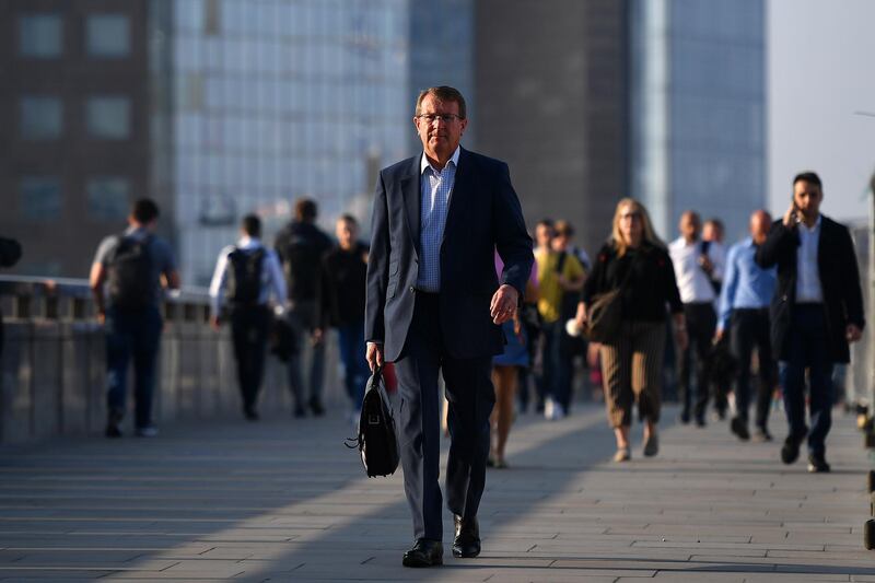 Commuters walk across London Bridge toward the City of London. AFP