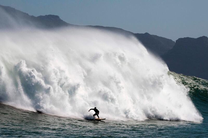 A surfer catches a wave at Sunset, a surfing spot between Hout Bay and Kommetjie that produces some of South Africa's biggest waves, in Cape Town.  AFP