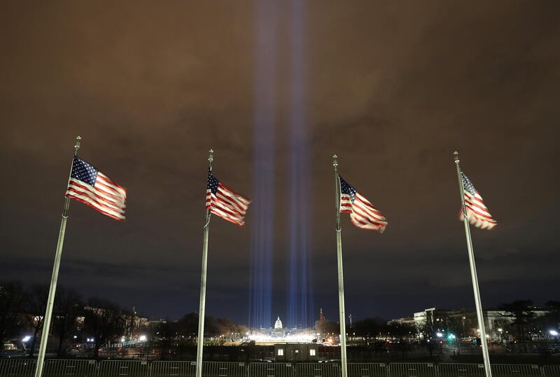 Blue lights are beamed into the sky over the 'Field of Flags' on the grounds of the National Mall at night ahead of the 59th Inaugural Ceremonies in Washington. Bloomberg
