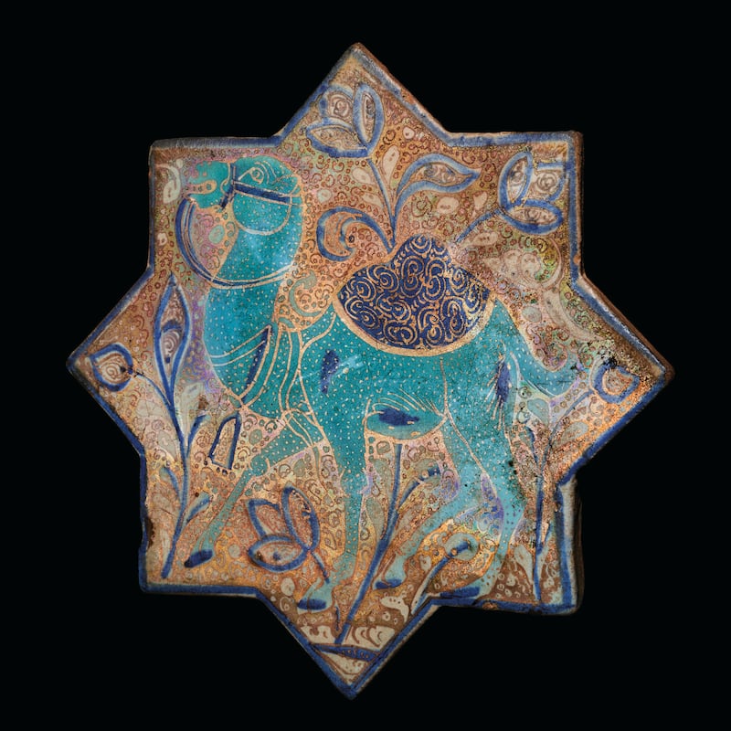 A Kashan Luster, turquoise and cobalt blue star tile depicting a camel with a saddle, from Iran. It was made in the later 13th and early 14th centuries.