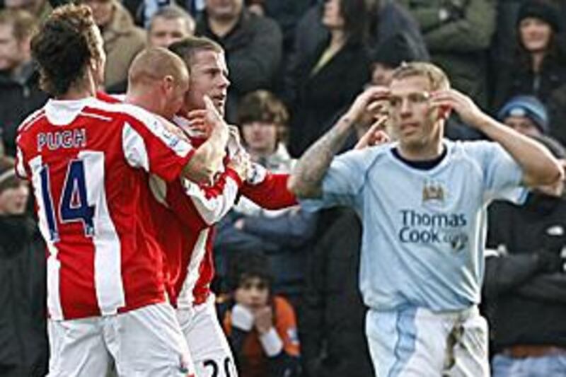 Manchester City's Craig Bellamy puts his hands to his head as James Beattie (20) celebrates with teammates after scoring for Stoke.