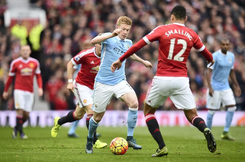 Manchester City's Belgian footballer Kevin De Bruyne (3rd R) is challenged by Manchester United's English defender Chris Smalling (2nd R) during the English Premier League football match between Manchester United and Manchester City at Old Trafford in Manchester, north west England, on October 25, 2015.  AFP PHOTO / PAUL ELLIS

RESTRICTED TO EDITORIAL USE. No use with unauthorized audio, video, data, fixture lists, club/league logos or 'live' services. Online in-match use limited to 75 images, no video emulation. No use in betting, games or single club/league/player publications. (Photo by PAUL ELLIS / AFP)