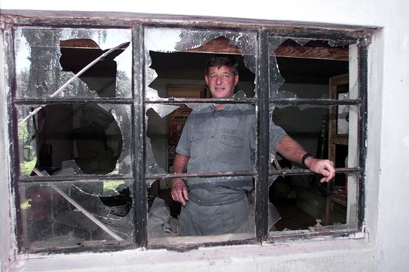 Zimbabwean farmer Paul Retzlaff stands 12 April 2000 in front of a broken window at his home in Arcturus, Gormonzi district, 30 kms east of Harare, a day after clashes broke out at his farm when drunken would-be squatters invaded the property before being repelled by black farm workers. Retzlaff said shots had been fired by the invaders, including a leading veteran of the war against white rule in the 1970s. The couple was saved after black farm workers from neighboring farms responded to a call for help over ham radio. His wife Liz said the invaders, who appeared drunk, were shouting that they had President Robert Mugabe's permission to invade the property.   / AFP PHOTO / ALEXANDER JOE